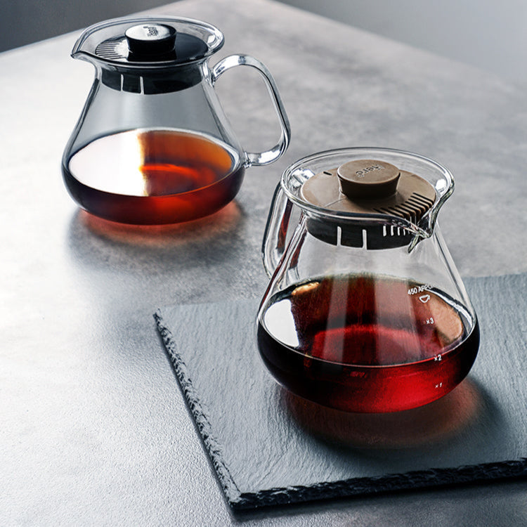 Two glass coffee pots with coffee on a gray surface