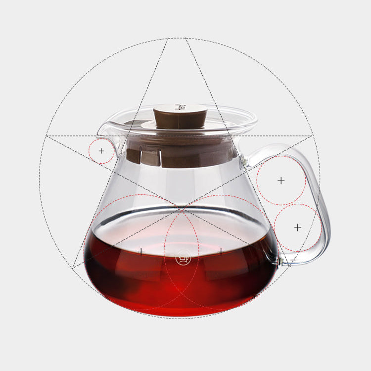 Clear glass teapot with a brown lid filled with red liquid on a light gray background