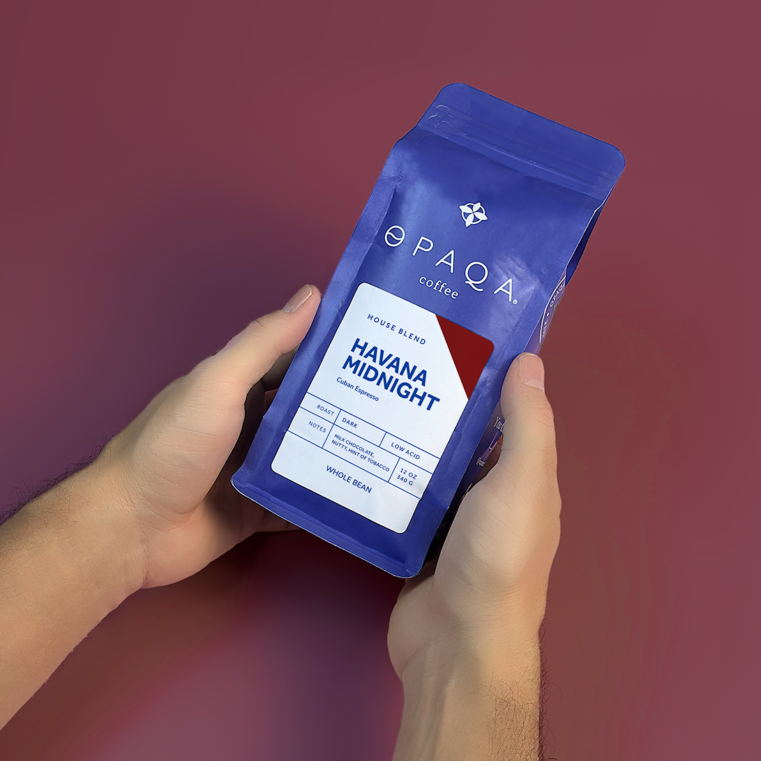 Havana Midnight coffee bag held in hands against a rich burgundy background, highlighting its bold flavor