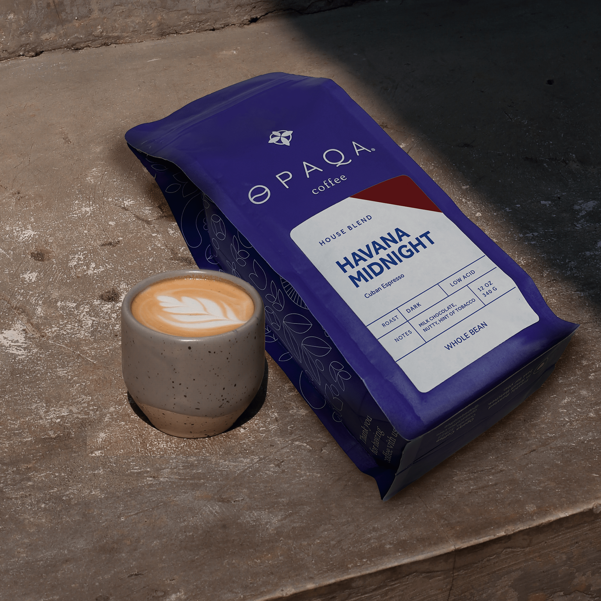 Havana Midnight coffee bag placed on a rustic surface with a cappuccino, evoking rich, nutty notes